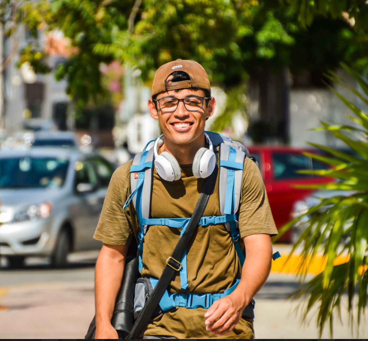 Lincoli walking through a city with a backpack and headphones